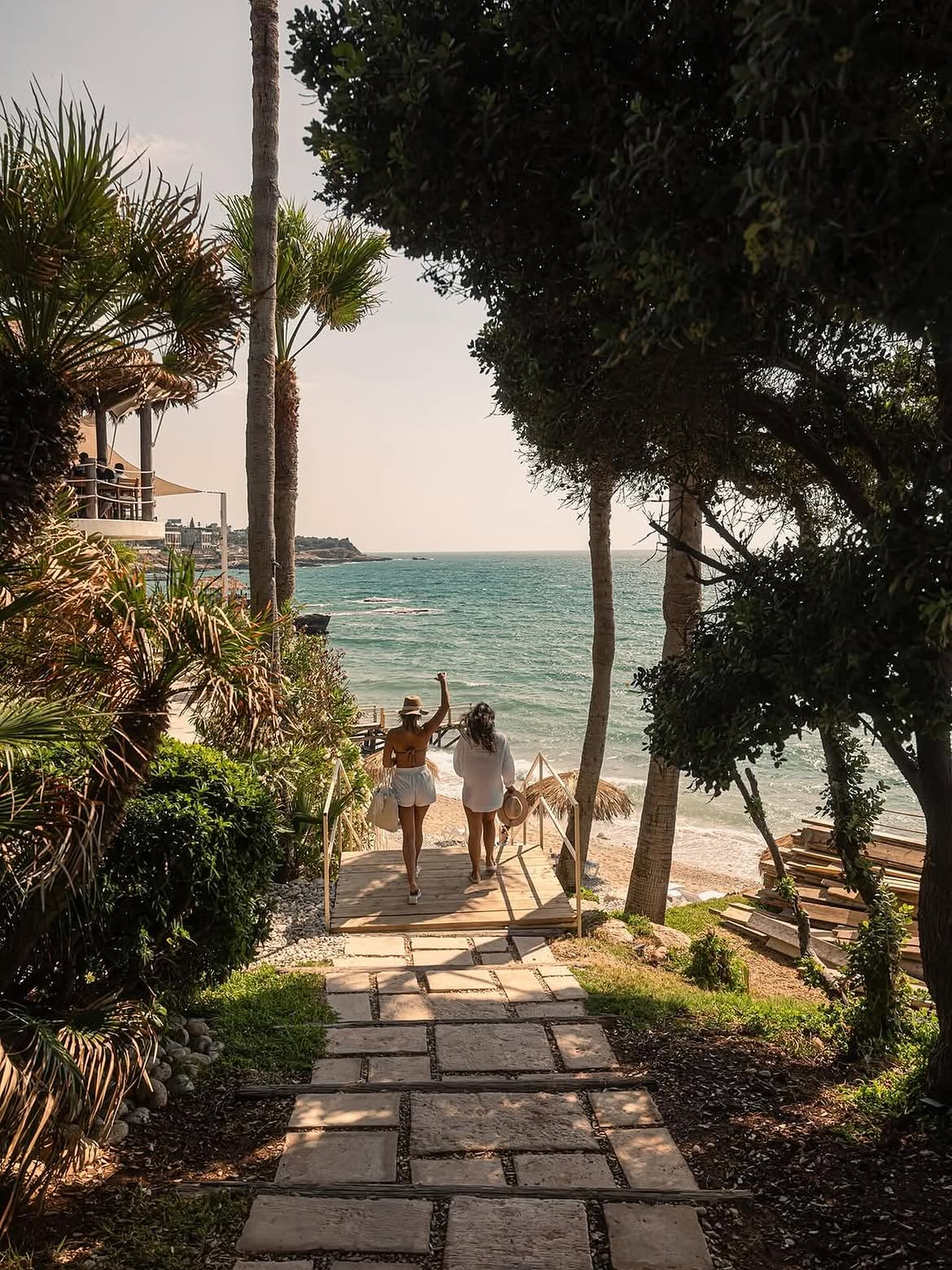 Two guests walking the stone path down through the trees to the beach