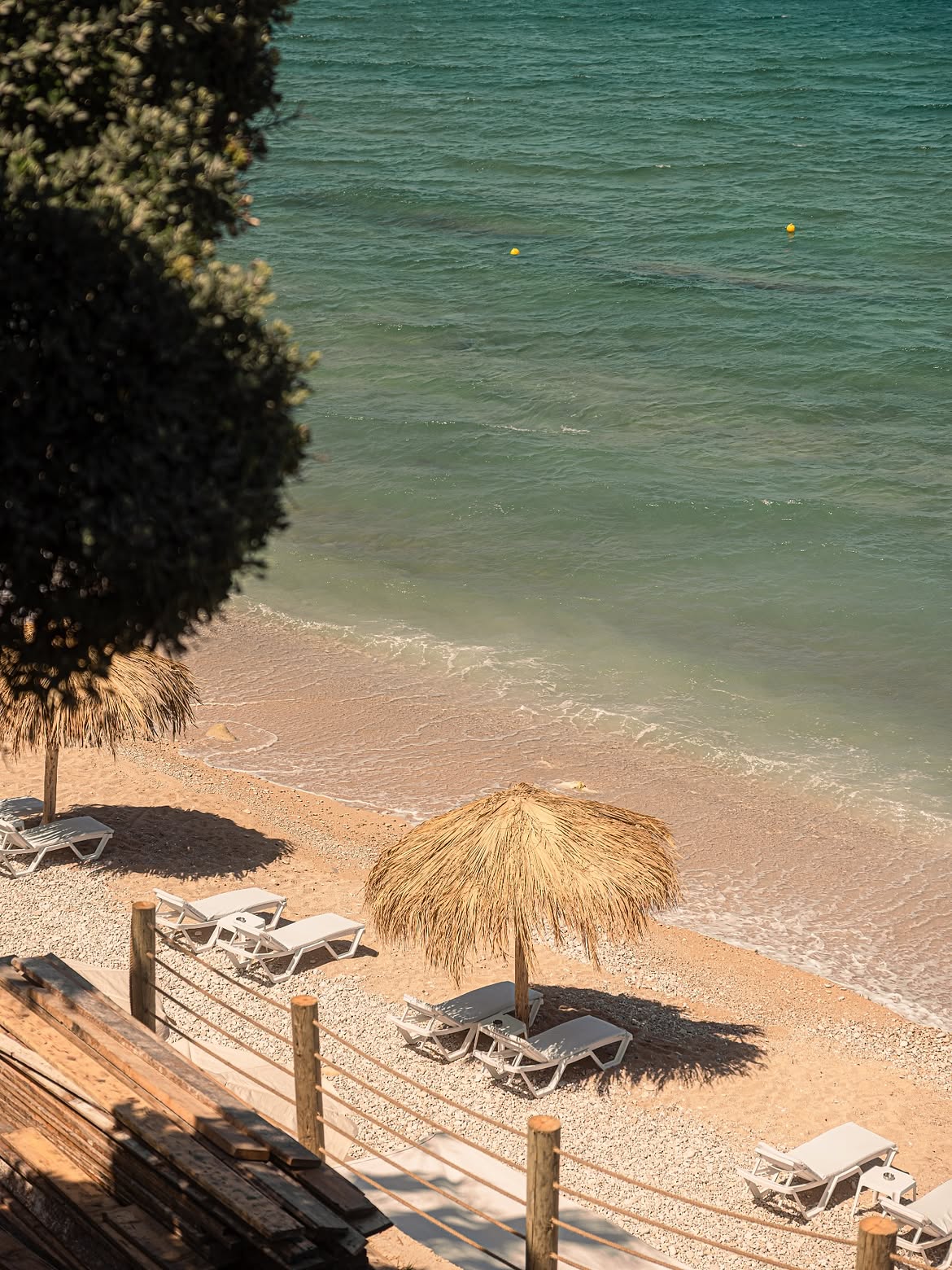 Aerial view of thatched parasols and sunbeds on the sand at Bonita Bay